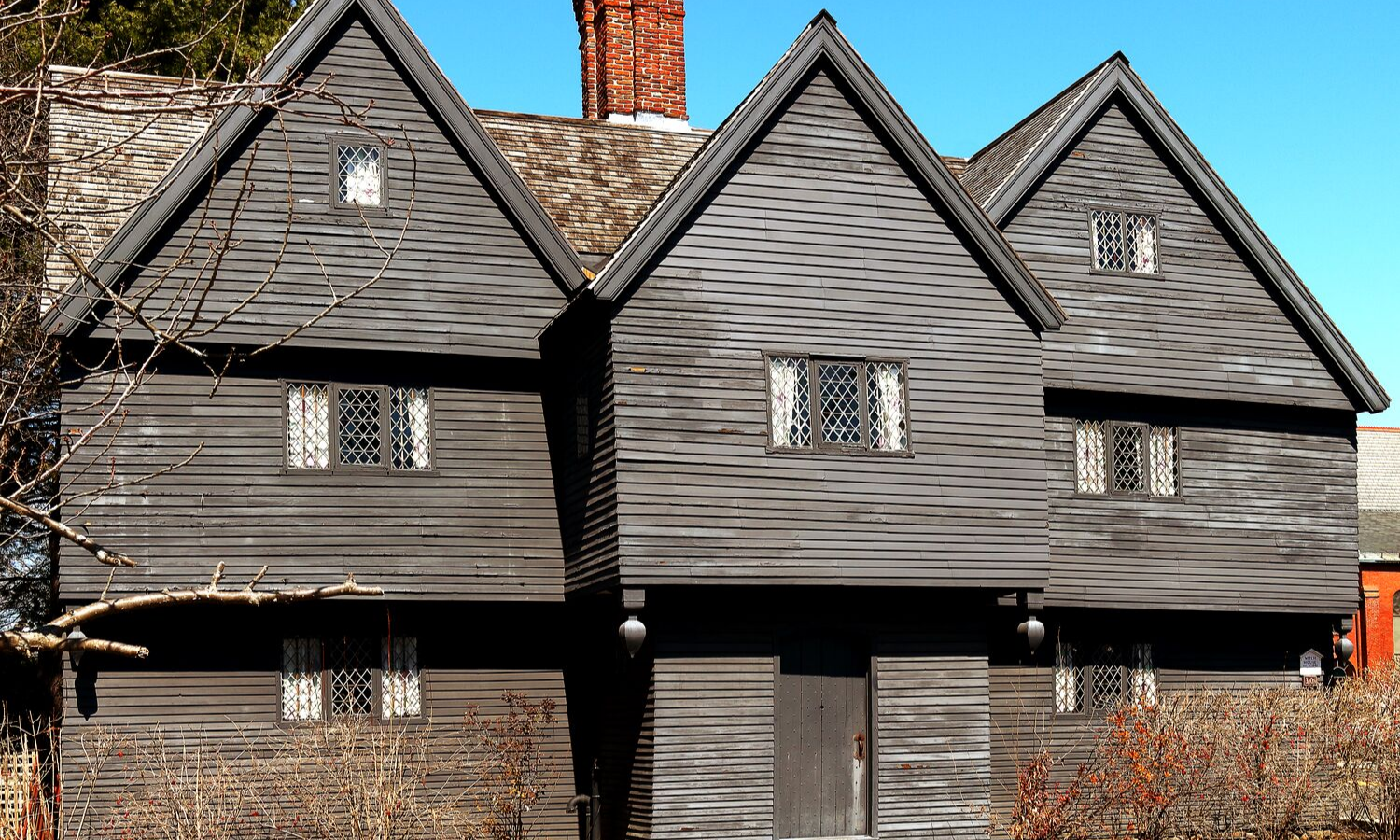 Picture of black, wooden panelled mansion. 